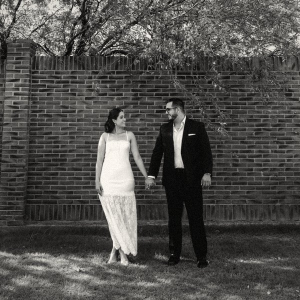 Jocelyn Denisse y Luis Humberto frente a un muro de ladrillo